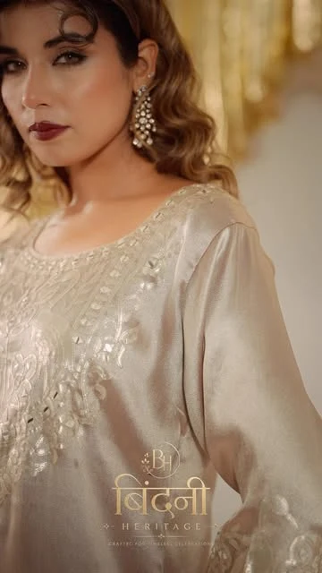 Model wearing a soft ivory embellished suit