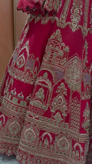 Close-up of architectural gold embroidery on a red lehenga